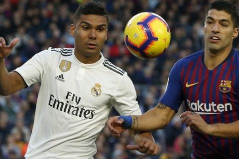 Barcelona forward Luis Suarez, right, duels for the ball with Real midfielder Casemiro during the Spanish La Liga soccer match between FC Barcelona and Real Madrid at the Camp Nou stadium in Barcelona, Spain, Sunday, Oct. 28, 2018. (AP Photo/Joan Monfort)