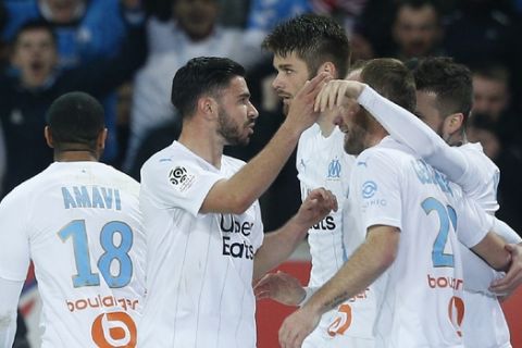 Marseille's players celebrate after scoring their side's first goal during the French League One soccer match between Lille and Marseille at the Lille Metropole stadium in Villeneuve d'Ascq, northern France, Sunday, Feb. 16, 2020. (AP Photo/Michel Spingler)