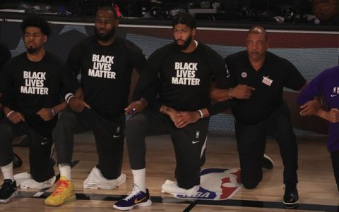 Los Angeles Lakers' LeBron James, second from left, wears a Black Lives Matter shirt and kneels with teammates during the national anthem prior to an NBA basketball game against the Los Angeles Clippers, Thursday, July 30, 2020, in Lake Buena Vista, Fla. (Mike Ehrmann/Pool Photo via AP)