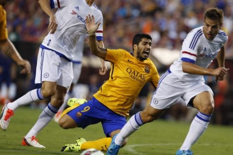 Barcelona Luis Alberto Suárez Díaz, center, falls as Chelsea César Azpilicueta, right, moves to the ball during the first half of an International Champions Cup soccer match in Washington, Tuesday, July 28, 2015. Chelsea won 3-2 on penalty kicks. (AP Photo/Carolyn Kaster)