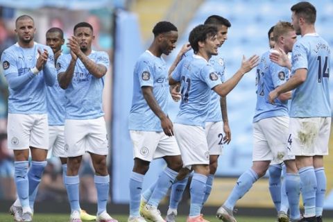 Manchester City's David Silva is applauded by team mates at the end of the English Premier League soccer match between Manchester City and Norwich City at the Etihad Stadium in Manchester, England, Sunday, July 26, 2020. (AP Photo/Dave Thompson, Pool)