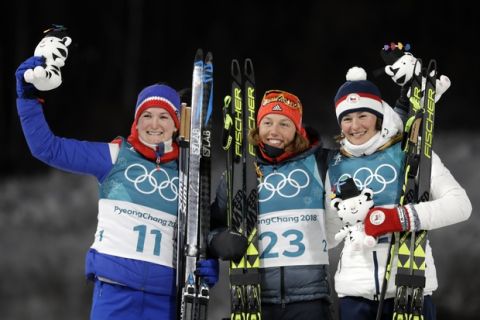 Gold medalist Laura Dahlmeier, of Germany, center, silver medalist Marte Olsbu, of Norway, left and bronze medalist Veronika Vitkova, of the Czech Republic, right, celebrate during the venue ceremony after the women's 7.5km biathlon sprint at the 2018 Winter Olympics in Pyeongchang, South Korea, Saturday, Feb. 10, 2018. (AP Photo/Andrew Medichini)