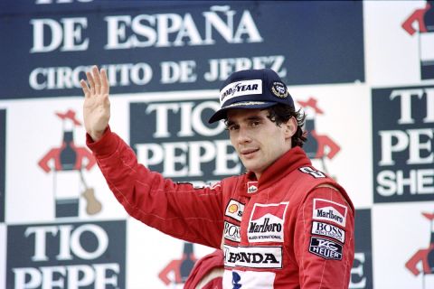 Brazilian Formula One pilot Ayrton Senna waves from podium on October 1, 1989 after winning the Spanish Grand Prix, ahead Gehard Berger of Austria and Alain Prost of France. (Photo by Jean-Loup GAUTREAU and Pascal PAVANI / AFP)