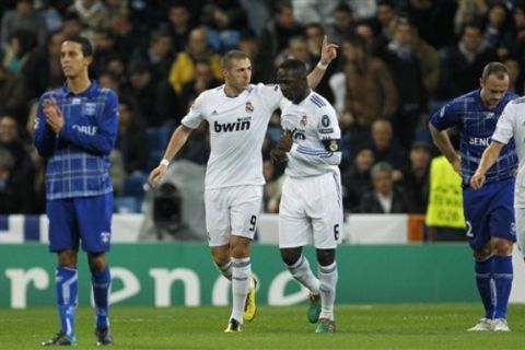 Real Madrid's Karim Benzema from France, second left, reacts after scoring against Auxerre next to teammate Mahamadou Diarra from Mali, third left, during their Group G Champions League soccer match at the Santiago Bernabeu stadium in Madrid Wednesday, Dec. 8, 2010. (AP Photo/Victor R. Caivano)