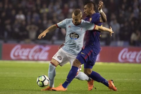 RC Celta's Stanislav Lobotka, left, challenges for the ball with Barcelona's Paulinho during a Spanish La Liga soccer match between RC Celta and Barcelona at the Balaidos stadium in Vigo, Spain, Tuesday April 17, 2018. (AP Photo/Lalo R. Villar)