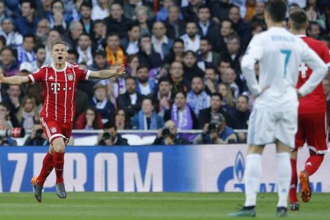 Real Madrid's Cristiano Ronaldo, second right, looks on as Bayern's Joshua Kimmich celebrates after scoring the opening goal during the Champions League semifinal second leg soccer match between Real Madrid and FC Bayern Munich at the Santiago Bernabeu stadium in Madrid, Spain, Tuesday, May 1, 2018. (AP Photo/Paul White)