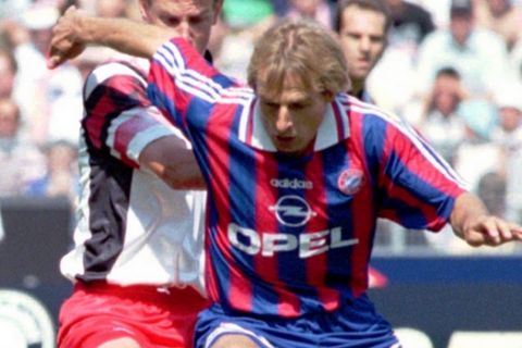 Jurgen Klinsmann of Bayern Munich, a former Tottenham Hotspur player, is chased by Stephane Henchoz from Hamburg SV in the first League encounter in Munich Saturday, Aug. 12, 1995. Munich won 3-2.(AP PHOTO/FRANK AUGSTEIN)