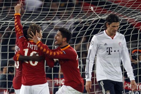 AS Roma's Francesco Totti (L) celebrates with his team mate Marco Borriello (C) after scoring from a penalty as Bayern Munich's Mario Gomez looks down during their Champions League Group E soccer match at the Olympic stadium in Rome, November 23, 2010.   REUTERS/Tony Gentile   (ITALY - Tags: SPORT SOCCER)