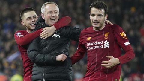 Liverpool's Under 23 coach Neil Critchley, center, celebrates with Liverpool's Pedro Chirivella, right, and Liverpool's Adam Lewis after winning the English FA Cup Fourth Round replay soccer match between Liverpool and Shrewsbury Town at Anfield Stadium, Liverpool, England, Tuesday, Feb. 4, 2020. Liverpool won 1-0. (AP Photo/Jon Super)