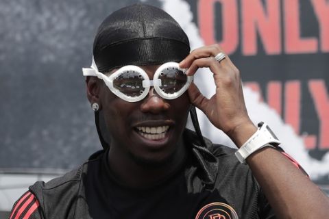 Manchester United's soccer player Paul Pogba, adjusts his goggles, given by a fan, during a meeting with his fans following a media day in Seoul, South Korea, Thursday, June 13, 2019. Pogba is in Seoul as a part of his Asian tour. (AP Photo/Lee Jin-man)