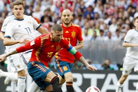 Spain's Sergio Ramos plays the ball chased by Russia's Roman Zobnin during their round of 16 match at the 2018 soccer World Cup at the Luzhniki Stadium in Moscow, Russia, Sunday, July 1, 2018. (AP Photo/Antonio Calanni)