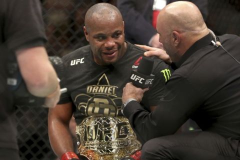 Daniel Cormier is interviewed by Joe Rogan after a win over Volkan Oezdemir after a light-heavyweight championship mixed martial arts bout at UFC 220, Saturday, January 20, 2018, in Boston. Cormier retained the title via 2nd round TKO. (AP Photo/Gregory Payan)