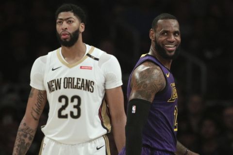 Los Angeles Lakers' LeBron James, right, smiles as he walks past New Orleans Pelicans' Anthony Davis during the first half of an NBA basketball game Friday, Dec. 21, 2018, in Los Angeles. (AP Photo/Jae C. Hong)