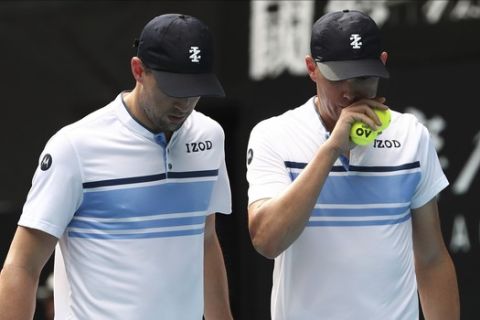 Mike Bryan, left, of the U.S. talks with his brother Bob during their third round doubles match against Croatia's Ivan Dodig and Slovakia's Filip Polasek at the Australian Open tennis championship in Melbourne, Australia, Monday, Jan. 27, 2020. (AP Photo/Dita Alangkara)