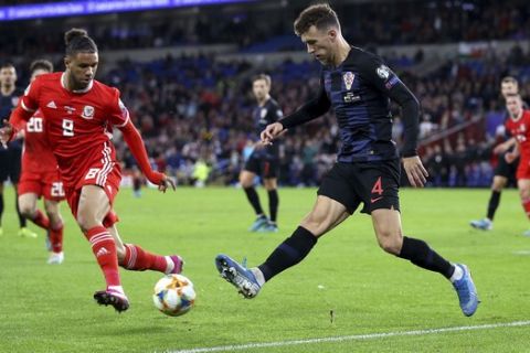 Wales' Tyler Roberts, left,and Croatia's Ivan Perisic in action during the UEFA Euro 2020 qualifying match at The Cardiff City Stadium, Cardiff, Sunday October 13, 2019.  (Nigel French/PA via AP)