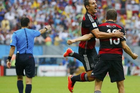 Germany's Thomas Mueller celebrates after scoring a goal with teammate Miroslav Klose (C) during their 2014 World Cup Group G soccer match against the U.S. at the Pernambuco arena in Recife June 26, 2014.  REUTERS/Brian Snyder (BRAZIL  - Tags: SOCCER SPORT WORLD CUP TPX IMAGES OF THE DAY)  