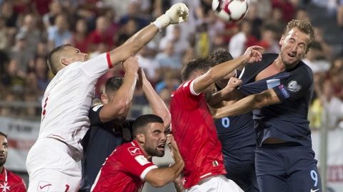 England's Harry Kane, right, and Malta's Goalkeeper Andrew Hogg, left, reach for the ball during the World Cup group F qualifying soccer match between Malta and England, at the Ta Qali stadium, in Valletta, Malta, Friday Sept.1, 2017. (AP Photo/Rene Rossignaud)