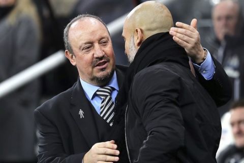Newcastle United manager Rafael Benitez, left, greets Manchester City manager Pep Guardiola during their English Premier League soccer match at St James' Park, Newcastle, England, Wednesday, Dec. 27, 2017. (Owen Humphreys/PA via AP)