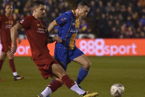 Shrewsbury's Shaun Whalley, right, duels for the ball with Liverpool's Dejan Lovren during the English FA Cup fourth round soccer match between Shrewsbury Town and Liverpool at the Montgomery Waters Meadow in Shrewsbury, England, Sunday, Jan. 26, 2020. (AP Photo/Rui Vieira)