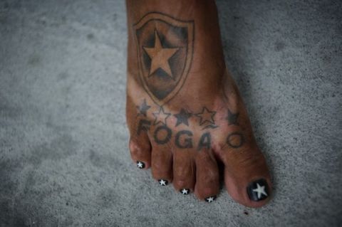 TO GO WITH AFP STORY by Javier Tovar
Brazilian football club Botafogo fan Delneri Martins Viana, a 69-year-old retired soldier, shows his tattoos at his home in Rio de Janeiro, Brazil, on January 18, 2014. Delneri has 83 tattoos on his body dedicated to Botafogo and describes himself as the club's biggest fan.   AFP PHOTO / YASUYOSHI CHIBA