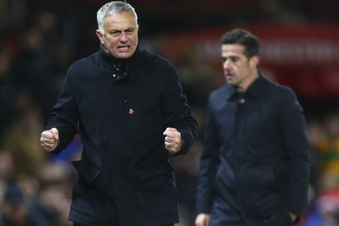 Manchester United manager Jose Mourinho reacts, next to Everton manager Marco Silva, right, during the last minutes of the English Premier League soccer match between Manchester United and Everton FC at Old Trafford in Manchester, England, Sunday Oct. 28, 2018. (AP Photo/Dave Thompson)
