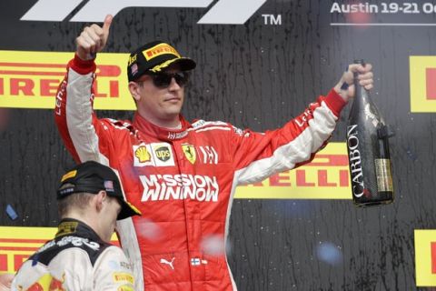 Ferrari driver Kimi Raikkonen, of Finland, celebrates after winning the Formula One U.S. Grand Prix auto race at the Circuit of the Americas, Sunday, Oct. 21, 2018, in Austin, Texas. Red Bull driver Max Verstappen, left, of the Netherlands, finished second. (AP Photo/Darron Cummings)