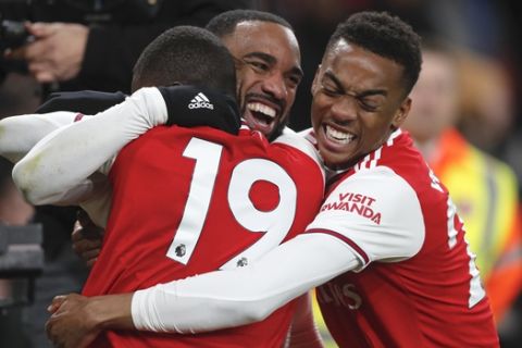Arsenal's Alexandre Lacazette, center, celebrates after scoring his side's fourth goal during the English Premier League soccer match between Arsenal and Newcastle at the Emirates Stadium in London, Sunday, Feb. 16, 2020.(AP Photo/Frank Augstein)