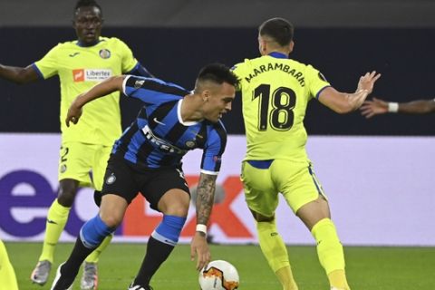 Inter Milan's Lautaro Martinez, left, challenges for the ball with Getafe's Mauro Arambarri during the Europa League round of 16 soccer match between Inter Milan and Getafe at the Veltins-Arena in Gelsenkirchen, Germany, Wednesday, Aug. 5, 2020. (Ina Fassbender, Pool Photo via AP)