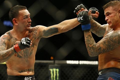 Max Holloway, left, jabs at Dustin Poirier during an interim lightweight title mixed martial arts bout at UFC 236 in Atlanta, early Sunday, April 14, 2019. (AP Photo/Michael Zarrilli)