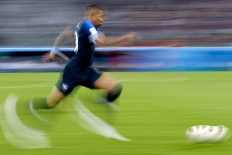 In this photo taken with slow shutter speed France's Kylian Mbappe runs with the ball during the semifinal match between France and Belgium at the 2018 soccer World Cup in the St. Petersburg Stadium, in St. Petersburg, Russia, Tuesday, July 10, 2018. (AP Photo/Petr David Josek)