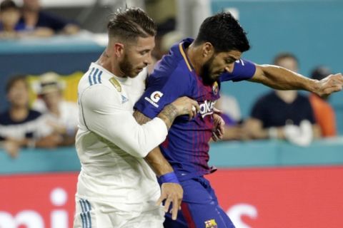 Barcelona's Luis Suarez, right, goes for the ball as Real Madrid's Sergio Ramos, left, defends during the first half of an International Champions Cup soccer match, Saturday, July 29, 2017, in Miami Gardens, Fla. (AP Photo/Lynne Sladky)