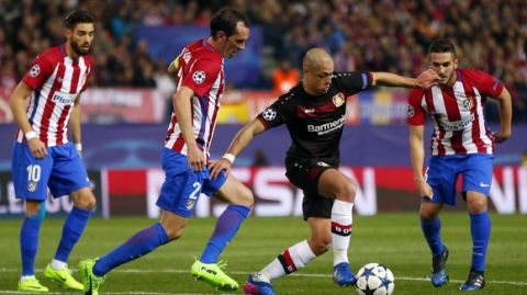 Leverkusen's Javier Hernandez, center right, is challenged by Atletico's Diego Godin, center left, during the Champions League round of 16 second leg soccer match between Atletico Madrid and Bayer Leverkusen at the Vicente Calderon stadium in Madrid, Spain, Wednesday, March 15, 2017. (AP Photo/Daniel Ochoa de Olza)