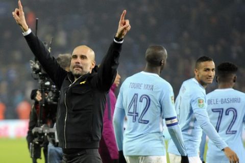 Manchester City manager Josep Guardiola celebrates towards fans after Manchester City beat Leicester City on penalties during the League Cup Quarter Final soccer match between Leicester City and Manchester City at the King Power Stadium in Leicester, England, Tuesday, Dec. 19, 2017. (AP Photo/Rui Vieira)