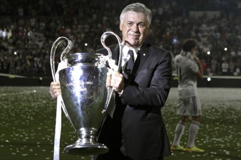 Real Madrid's coach Carlo Ancelotti lifts the Champion League trophy during celebrations at the Santiago Bernabeu stadium, in Madrid, Spain, Sunday, May 25, 2014, after the team won the Champions League final soccer match in Lisbon, Portugal by beating Atletico Madrid. (AP Photo/Gabriel Pecot)
