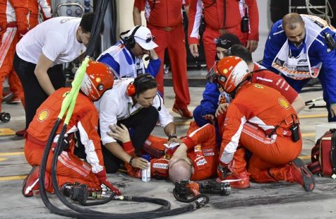 Ferrari mechanic Francesco, lies on the ground after being bitted by Ferrari driver Kimi Raikkonen during a pit stop the Bahrain Formula One Grand Prix, at the Formula One Bahrain International Circuit in Sakhir, Bahrain, Sunday, April 8, 2018. (Pool/Giuseppe Cacace Via AP)