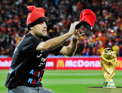 An unidentified man tries to place a hat on the World Cup trophy before the World Cup final soccer match between the Netherlands and Spain at Soccer City in Johannesburg, South Africa, Sunday, July 11, 2010.   (AP Photo/Martin Meissner)