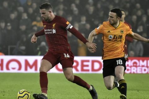 Liverpool's Jordan Henderson, left, duels for the ball with Wolverhampton Wanderers' Diogo Jota during the English Premier League soccer match between Wolverhampton Wanderers and Liverpool at the Molineux Stadium in Wolverhampton, England, Thursday, Jan. 23, 2020. (AP Photo/Rui Vieira)