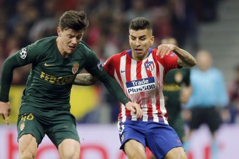 Monaco's Giulian Biancone, left, duels for the ball with Atletico Madrid's Angel Correa during a Group A Champions League soccer match between Atletico Madrid and Monaco at the Metropolitano stadium in Madrid, Wednesday, Nov. 28, 2018. (AP Photo/Paul White)