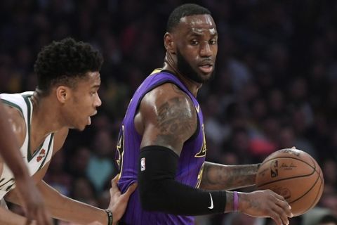 Los Angeles Lakers forward LeBron James, right, tries to move past Milwaukee Bucks forward Giannis Antetokounmpo during the first half of an NBA basketball game Friday, March 1, 2019, in Los Angeles. (AP Photo/Mark J. Terrill)