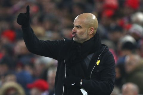 Manchester City's manager Pep Guardiola gives a thumbs up to his players during the English Premier League soccer match between Liverpool and Manchester City at Anfield Stadium, in Liverpool, England, Sunday Jan. 14, 2018. (AP Photo/Dave Thompson)