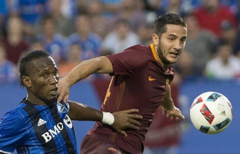 Montreal Impact's Didier Drogba, left, challenges AS Roma's Kostas Manolas during the first half of a friendly soccer match in Montreal, Wednesday, Aug. 3, 2016. (Graham Hughes/The Canadian Press via AP)