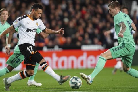 Valencia's Francis Coquelin, left, duels for the ball against Real Madrid's Toni Kroos during the Spanish La Liga soccer match between Valencia and Real Madrid at the Mestalla Stadium in Valencia, Spain, Sunday, December 15, 2019. (AP Photo/Alberto Saiz)