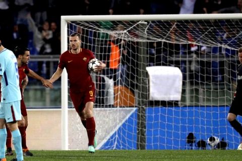 Roma's Edin Dzeko, third from left, is congratulated by teammate Roma's Kevin Strootman, second left, after he scored his side's first goal passing Barcelona goalkeeper Marc-Andre ter Stegen, right, during the Champions League quarterfinal second leg soccer match between between Roma and FC Barcelona, at Rome's Olympic Stadium, Tuesday, April 10, 2018. (AP Photo/Gregorio Borgia)