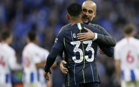 Manchester City coach Pep Guardiola hugs Manchester City's Gabriel Jesus at the end of during the English FA Cup semifinal soccer match between Manchester City and Brighton & Hove Albion at Wembley Stadium in London, Saturday, April 6, 2019. Jesus scored the gaol in Manchester City's 1-0 win. (AP Photo/Tim Ireland)