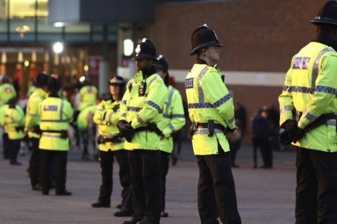 Police officers keep watch ahead of the English League Cup soccer match between Manchester United and Manchester City at Old Trafford stadium in Manchester, Wednesday, Oct. 26, 2016. (AP Photo/Dave Thompson)