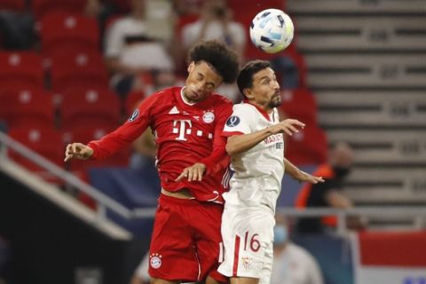 Bayern's Leroy Mane, left, jumps for a header with Sevilla's Jesus Navas during the UEFA Super Cup soccer match between Bayern Munich and Sevilla at the Puskas Arena in Budapest, Hungary, Thursday, Sept. 24, 2020. (AP Photo/Laszlo Balogh, Pool)