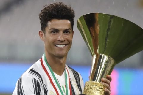 Juventus' Cristiano Ronaldo holds the cup of the Serie A championship after a Serie A soccer match between Juventus and Roma, at the Allianz stadium in Turin, Italy, Saturday, Aug.1, 2020. (AP Photo/Luca Bruno)