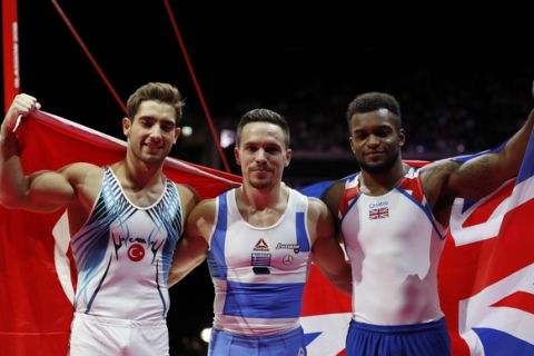Eleftherios Petrounias of Greece, center, celebrates after winning gold in the rings during the men's artistic gymnastics finals at the European Championships in Glasgow, Scotland, Sunday, Aug. 12, 2018. At left is At left is Ibrahim Colak of Turkey who took silver and at right is Courtney Tulloch of Great Britain who took bronze. (AP Photo/Darko Bandic)