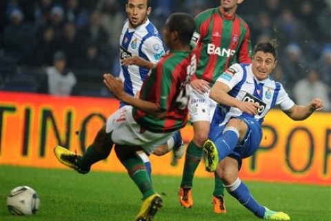 FC Porto's Cristian Rodriguez, right, from Uruguay scores the opening goal past Maritimo's Joao Guilherme, from Brazil, in a Portuguese League soccer match at the Dragao Stadium in Porto, Portugal, Saturday, Dec. 17, 2011.(AP Photo/Paulo Duarte)