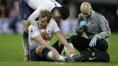 Tottenham's Son Heung-Min checks on teammate Harry Kane who sits on the pitch with an injury after the English Premier League soccer match between Tottenham Hotspur and Manchester United at Wembley stadium in London, England, Sunday, Jan. 13, 2019. (AP Photo/Matt Dunham)